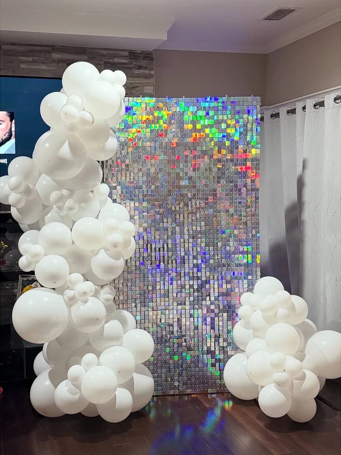 Alternate angle of the white shimmer wall birthday backdrop with balloon framing