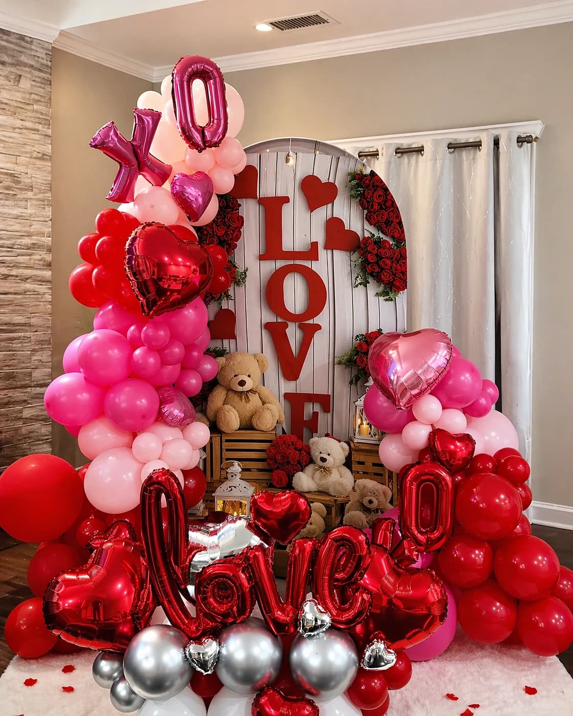 Romantic red and blush balloon backdrop with love lettering and floral accents