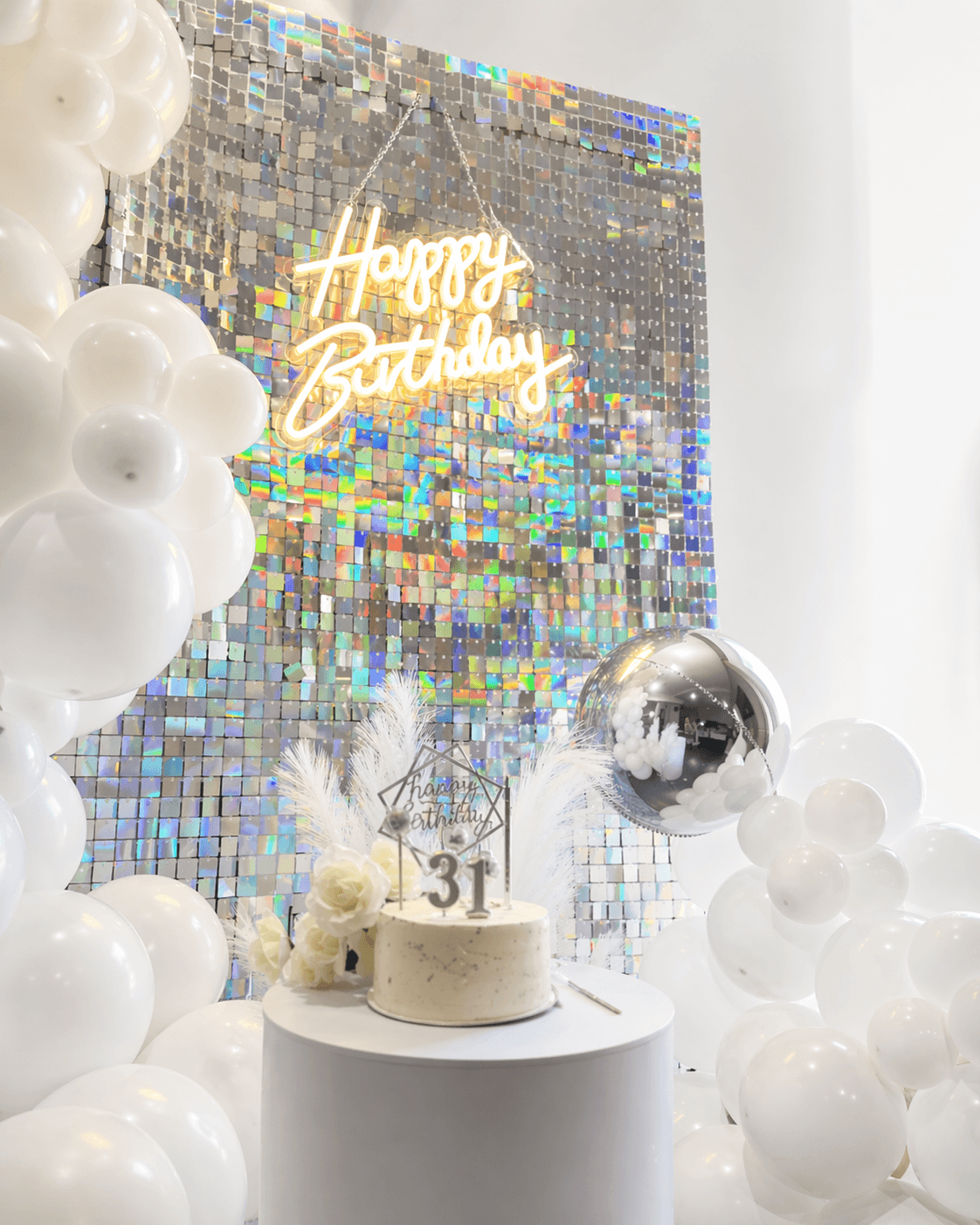 Refined monochrome balloon styling with shimmer wall and white balloon installation