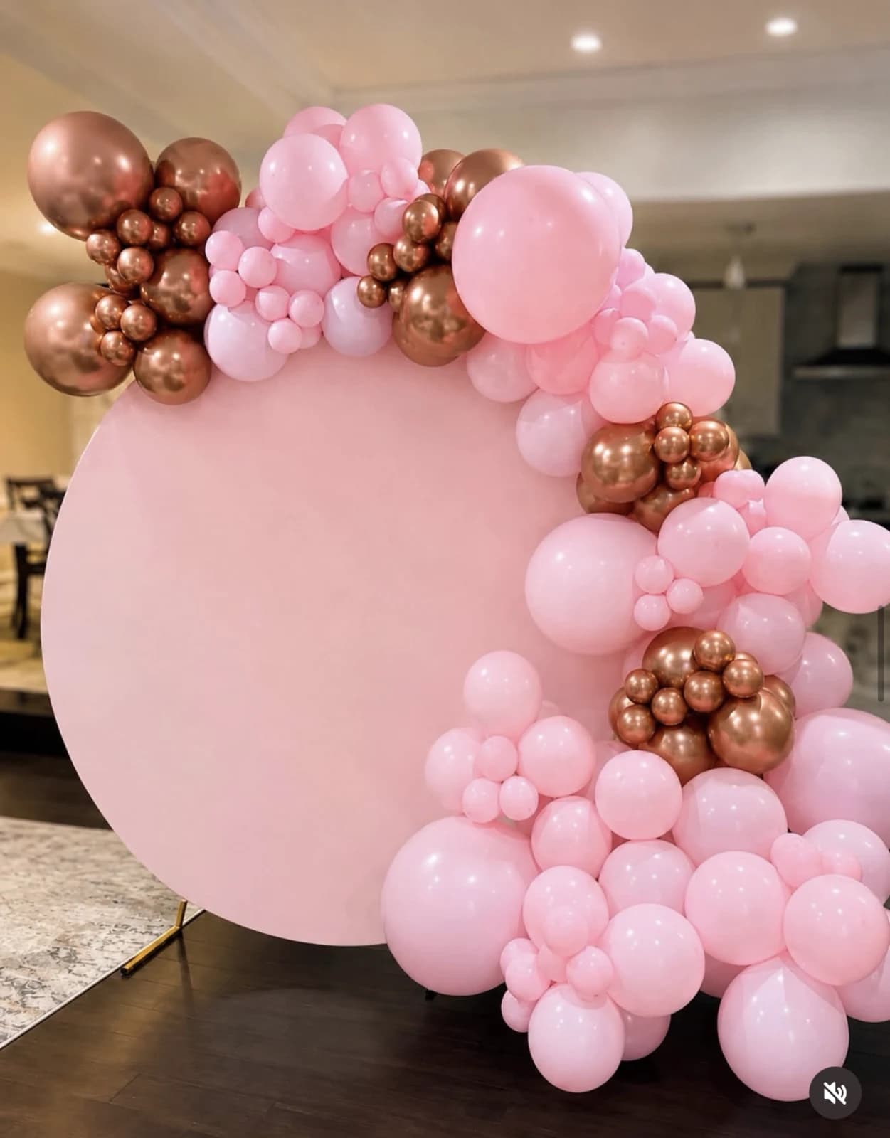 Pink and rose-gold balloon arrangement on a round backdrop