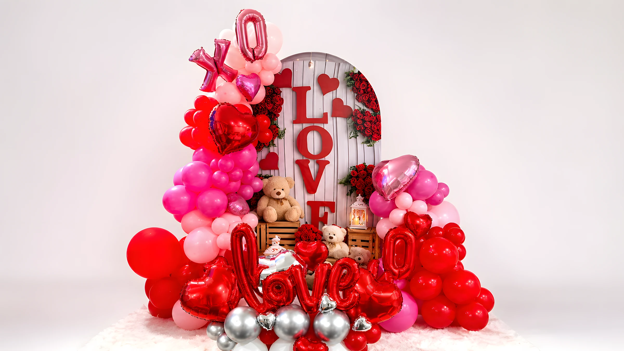 Romantic red and blush balloon backdrop with floral details