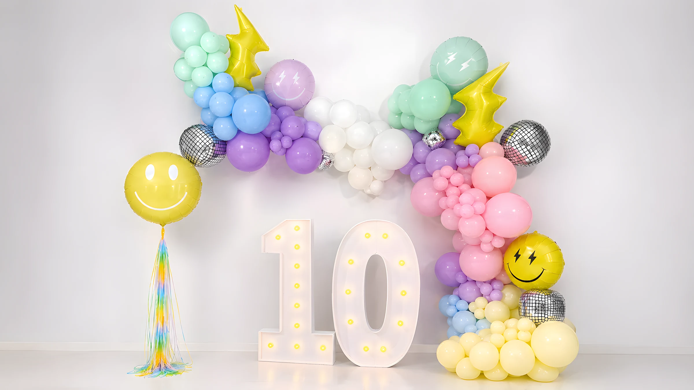 Pastel balloon installation with illuminated marquee numbers