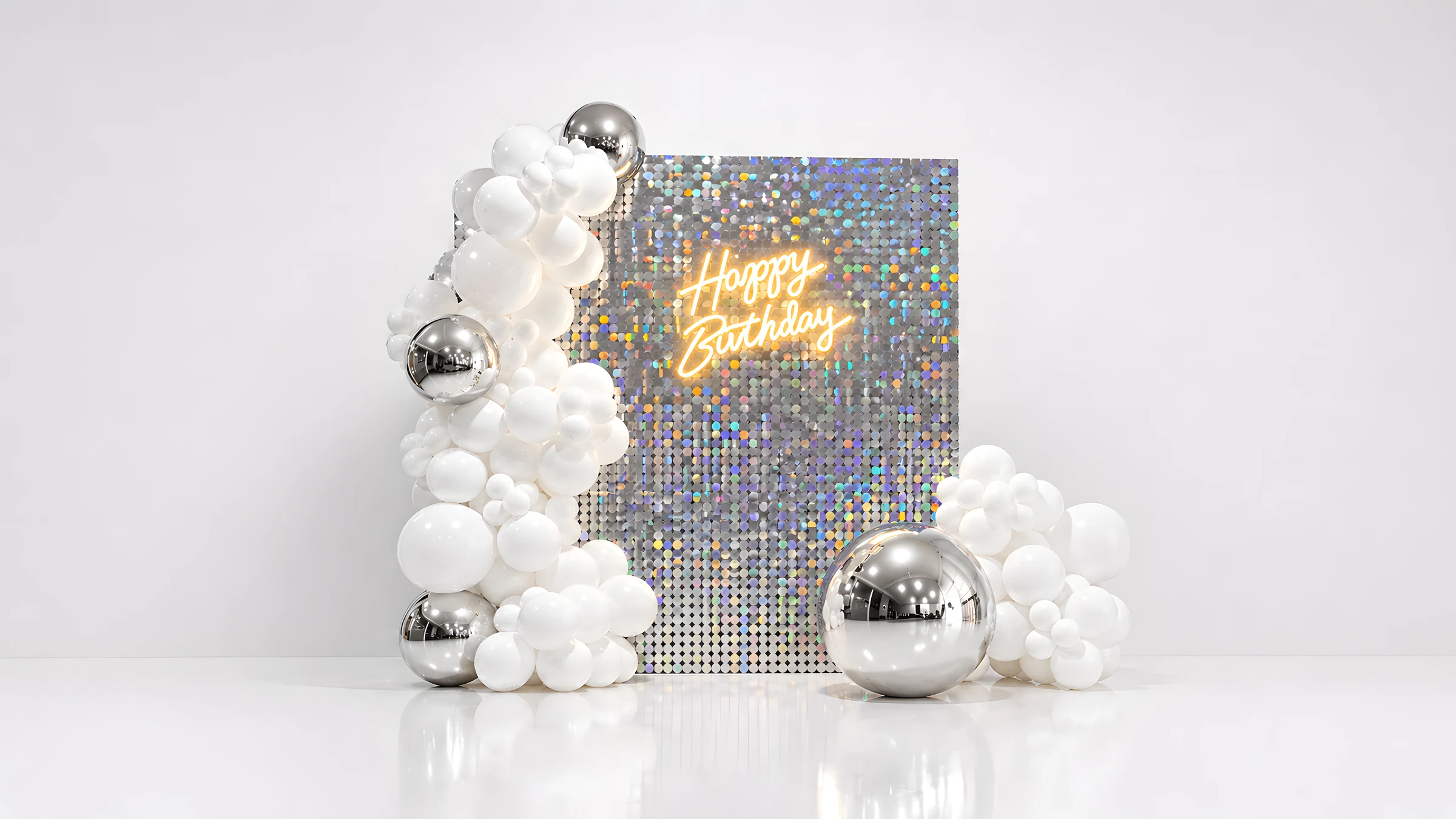 White balloon installation framing a shimmer wall birthday setup